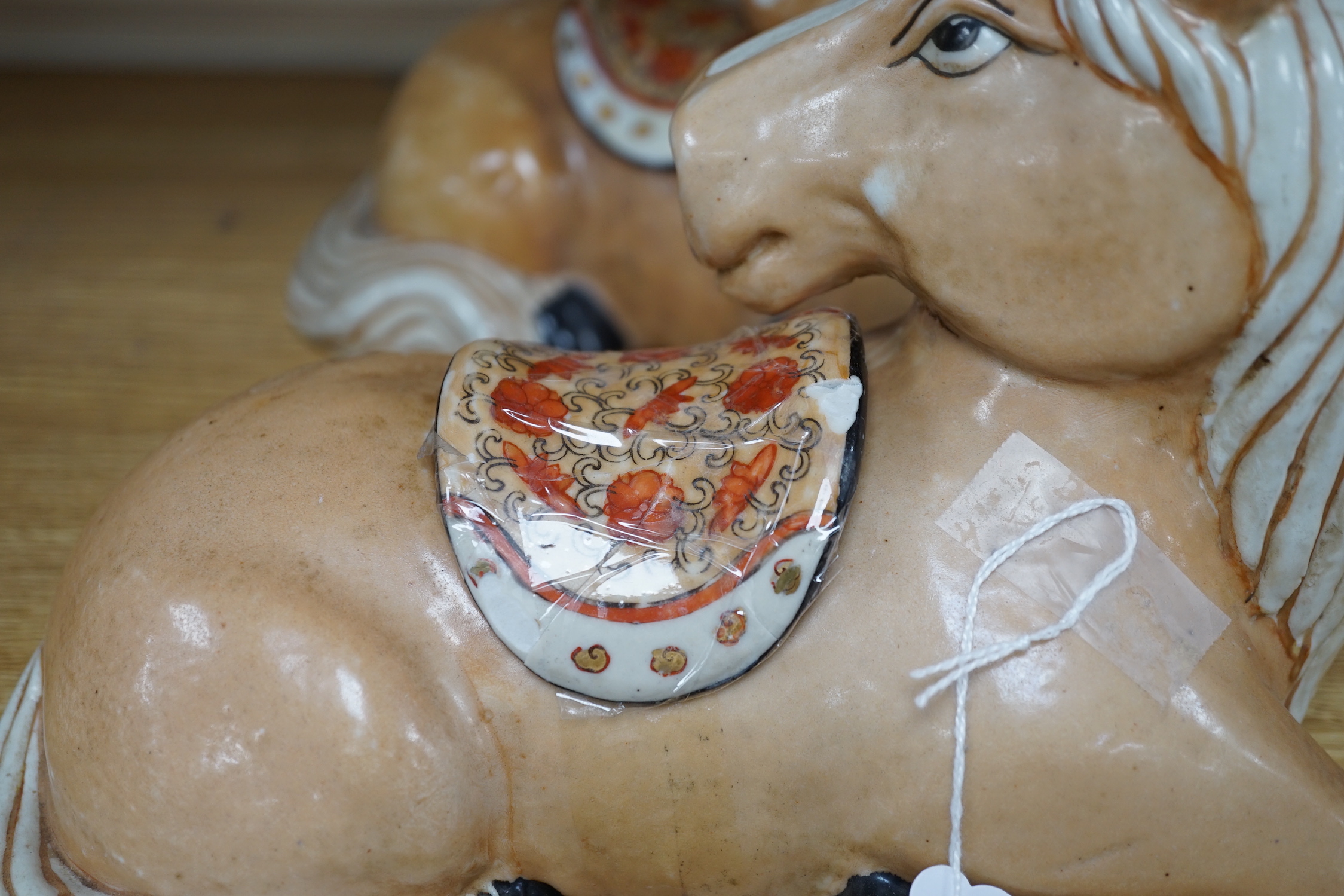 A pair of Chinese ceramic seated horses, 18cm high